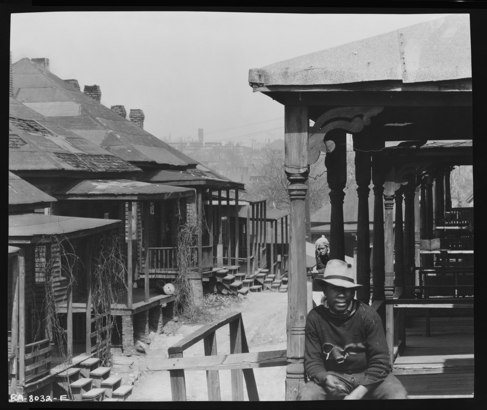 Wood-frame houses on a street sloping down toward a distant square tower. Walker Evans, Atlanta, Georgia (1936)